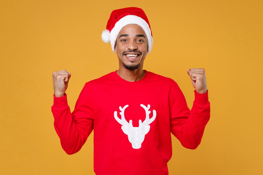 Young man wearing Santa-themed custom Christmas hoodie, smiling