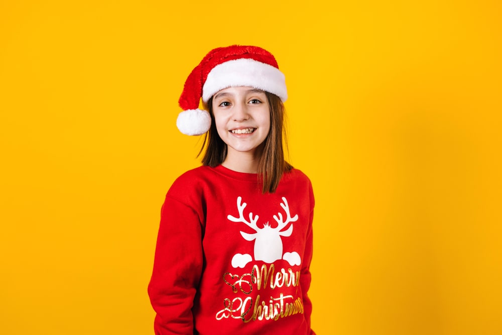 Little girl wearing custom Christmas hoodie and holding a gift